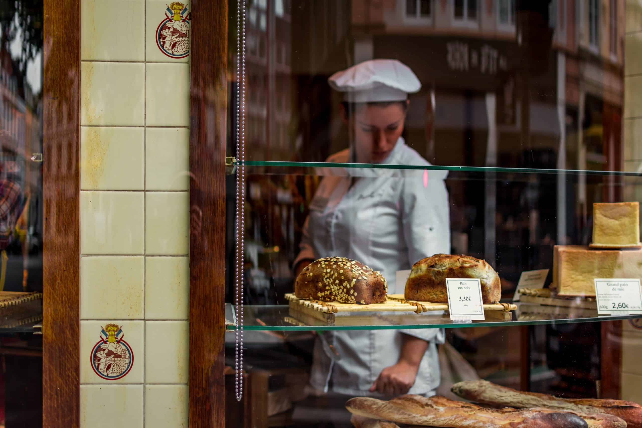 en baker ser på bakevarer som ligger for salg i vinduskarmen